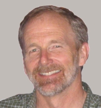 Gary is an older male with a beard. He is smiling.